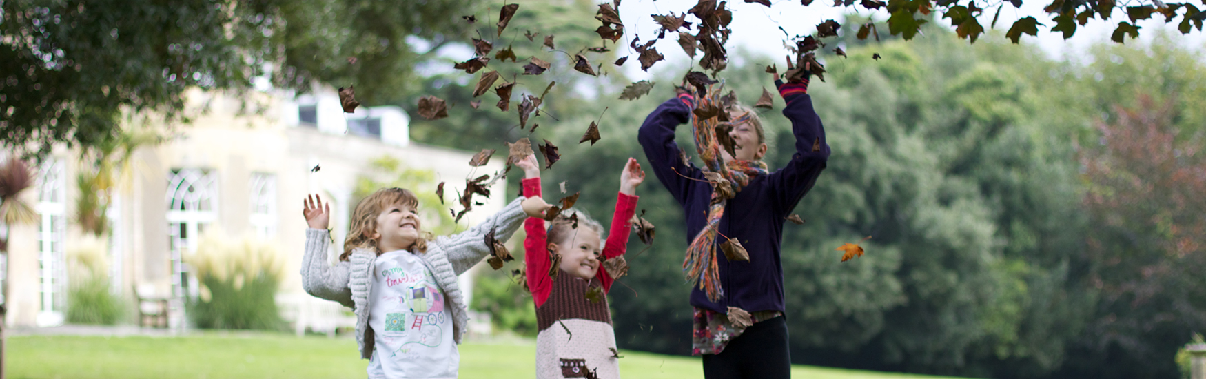 Kids playing in the winter leaves at Upton Country park in Poole 